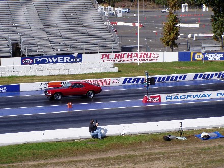 1999 Ford Crown Victoria - A photographer captures a red muscle car in action on the drag strip at Raceway Park.