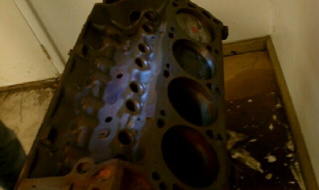 Bare V8 engine block standing on a floor