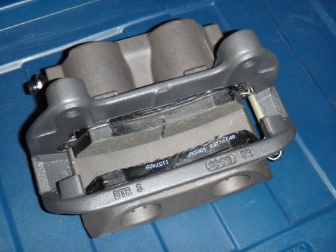 2003 Ford Taurus - A close-up view of a brake caliper assembly, showing the brake pads and visible part numbers.