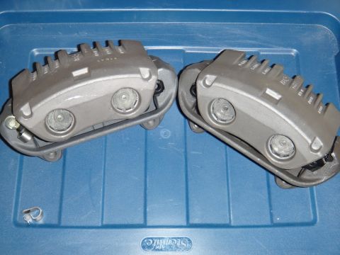2003 Ford Taurus - A pair of gray brake calipers are shown resting on a blue plastic surface.