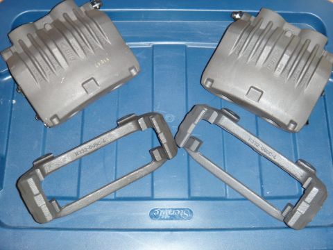 2003 Ford Taurus - A set of brake calipers and their corresponding mounting brackets are shown on a blue storage container.