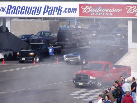 1999 Ford Crown Victoria - Multiple trucks and SUVs at a drag racing event at Raceway Park.
