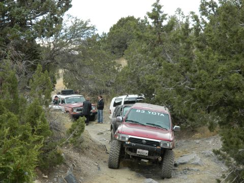 1979 Ford Bronco - Several off-road vehicles navigate a rocky trail, with one prominently displaying "83 YOTA" on its windshield.