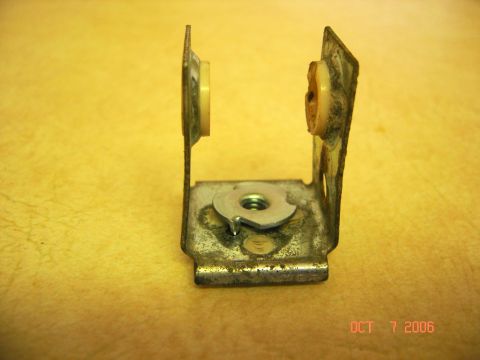 1996 Ford Bronco - Close-up of a metal bracket with plastic bushings and a nut, likely a spare part.
