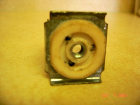 1996 Ford Bronco - A close-up shows a metal bracket with a plastic roller, likely a door lock component.