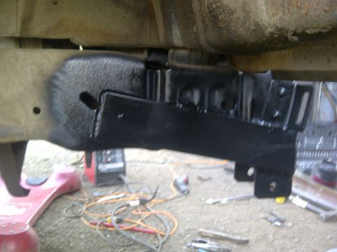 1979 Ford E250 - Close-up view of a black painted frame bracket, likely part of a vehicle's undercarriage.