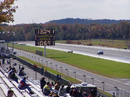 1999 Ford Crown Victoria - Drag racing event with scoreboard displaying times and spectators watching from the stands.