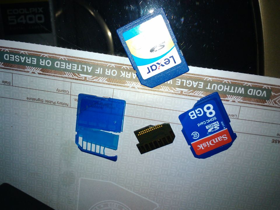 Lexar and SanDisk SD cards with an adapter on a document