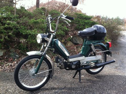 1981 Garelli Rally Sport - A green Garelli moped is parked outdoors on a gravel surface with a wooded background.