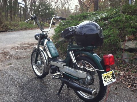 1981 Garelli Rally Sport - This moped, possibly a 1981 Garelli Rally Sport, is seen parked outdoors with a helmet secured to the rear rack.