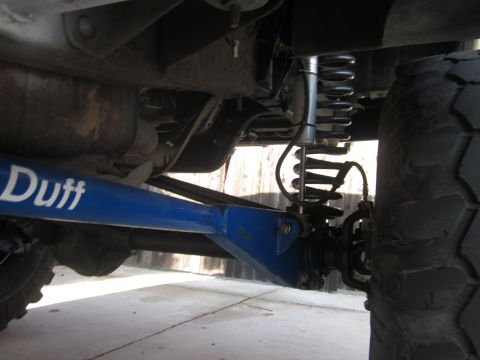 1985 Ford Bronco - Undercarriage view of a vehicle, highlighting a blue suspension component with "Duff" branding and visible coil springs.
