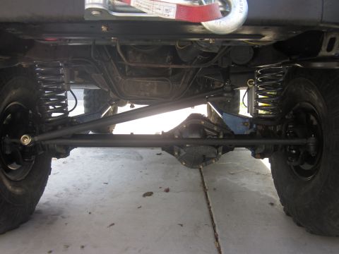 1985 Ford Bronco - The undercarriage of a 4x4 vehicle shows its robust suspension and drivetrain components.