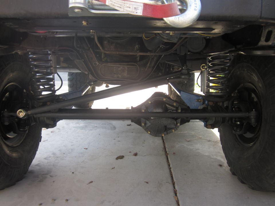 Underside view of a 4x4 with heavy-duty suspension components and a winch hook visible