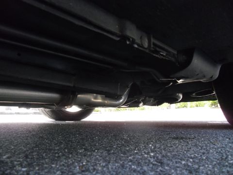 1978 Ford Bronco - Underside view of a vehicle's exhaust system and tire. Watermark present.