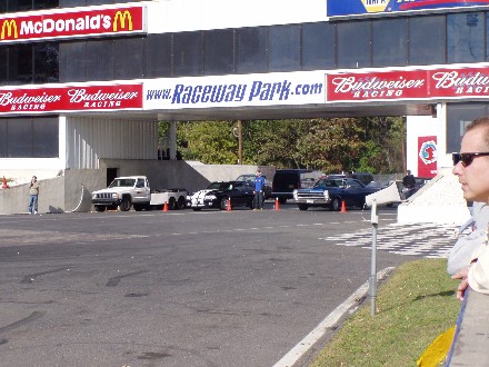 1999 Ford Crown Victoria - Multiple vehicles are staged at a drag strip under a banner for Raceway Park.