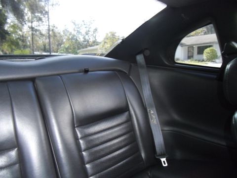 1978 Ford Bronco - Interior view of a car's back seat, with a house visible through the rear window.