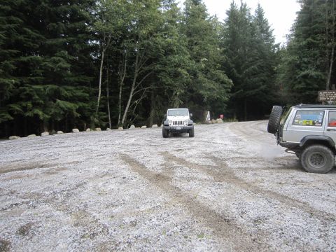 2008 Jeep Wrangler - Two Jeeps are parked on a gravel road surrounded by trees.