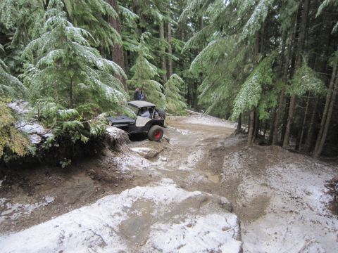 2008 Jeep Wrangler - A Jeep Wrangler navigates a challenging off-road trail with snow dusting the trees and ground.