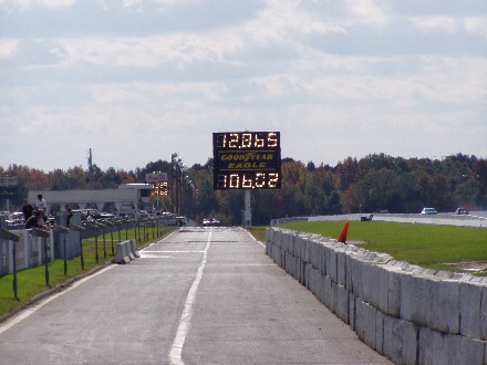 1999 Ford Crown Victoria - A drag strip scene with a large scoreboard displaying times and speeds.