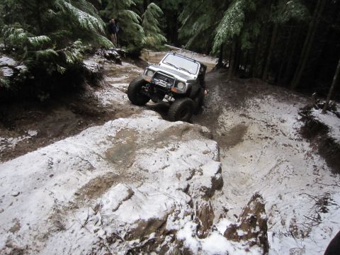 2008 Jeep Wrangler - Vehicle tackling a challenging off-road course in a snowy forest environment.