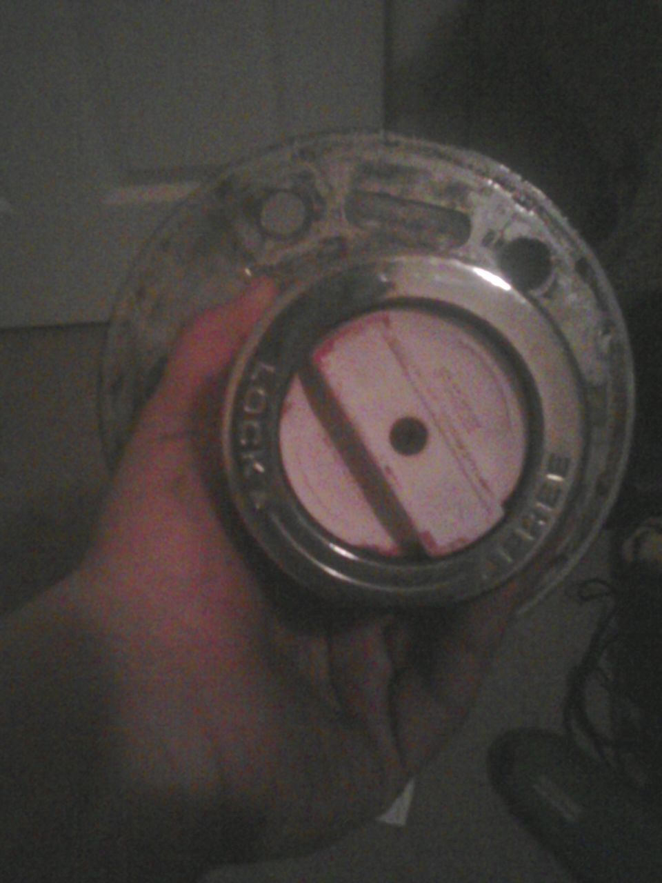 Hubcap with text LOCK FREE held by a hand
