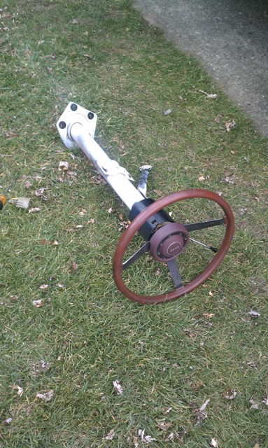 1978 Ford Bronco - A disassembled steering column and wheel are shown resting on a grassy area.
