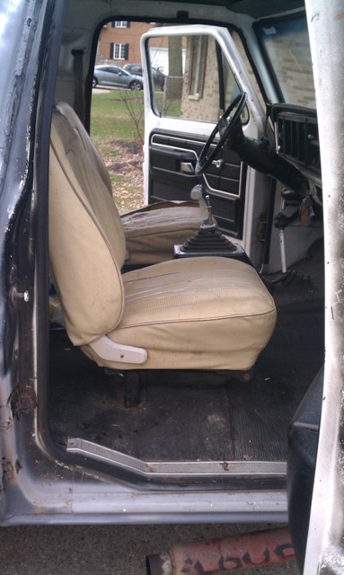 1978 Ford Bronco - Interior view of a vehicle, showing tan seats and a manual shifter.