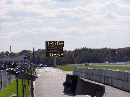 1999 Ford Crown Victoria - Drag strip scene with a scoreboard displaying race times and Goodyear Eagle branding.
