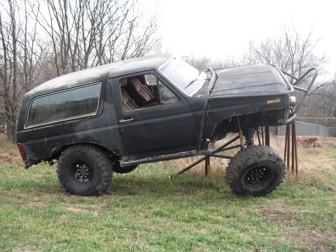 1986 Ford Bronco - This heavily modified SUV features a roll cage and lifted suspension, suggesting it is built for off-road use.