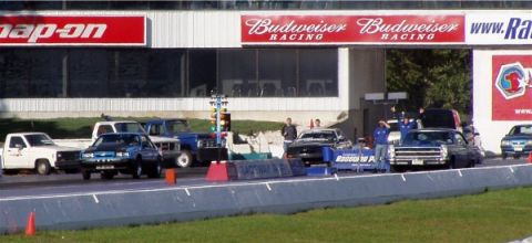 1999 Ford Crown Victoria - A blue sedan is lined up at a drag strip, ready for a race.