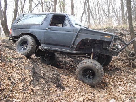 1986 Ford Bronco - This heavily modified SUV navigates a challenging off-road terrain.