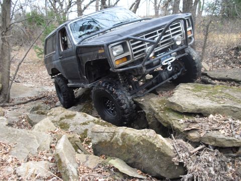 1986 Ford Bronco - This modified 1986 Ford Bronco navigates a rocky trail with its front end angled upwards.