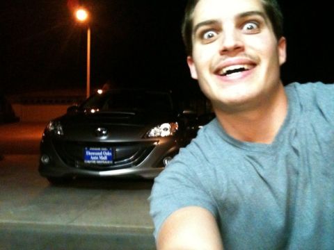 2000 Mercury Grand Marquis - A man takes a selfie with a dark sedan at night.