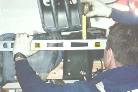 1994 Ford Bronco - Measuring a vehicle component with a level and tape measure.