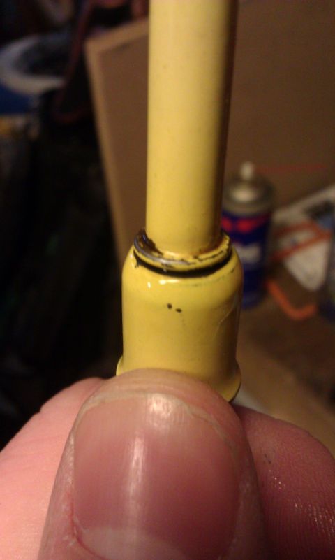 1984 Ford Bronco - A yellow automotive part is held by a finger, with a black O-ring visible.