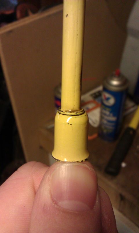1984 Ford Bronco - A yellow electrical component is held between fingers, with a spray can visible in the blurred background.
