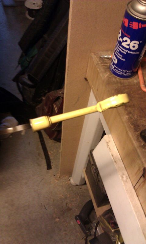1984 Ford Bronco - An oil dipstick is shown on a workbench, with a can of lubricant nearby.