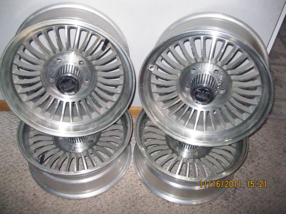 Four aluminum alloy wheels stacked, with a date stamp of 11/16/2011