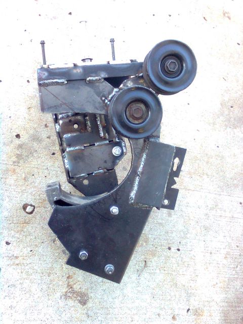 1984 Ford Bronco - A custom fabricated metal bracket assembly with pulleys, likely for an engine or drivetrain modification.