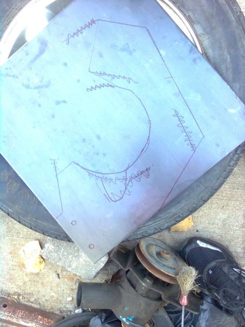 1984 Ford Bronco - A metal template with scribbled lines is placed on a tire, with engine components visible nearby.