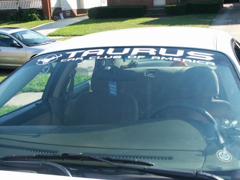 2001 Ford Taurus - Interior view of a car with a Taurus Car Club banner on the windshield; another car is parked nearby.