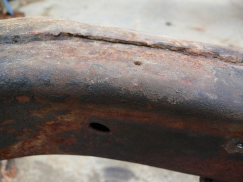 1976 Chevrolet Corvette - A close-up view of a heavily corroded metal frame component, indicating significant age and wear.