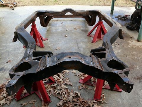 1976 Chevrolet Corvette - A car frame rests on red jack stands, suggesting a project in progress.