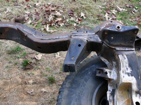 1976 Chevrolet Corvette - A close-up view of a vehicle's frame, showing signs of rust and repair, with a tire partially visible.