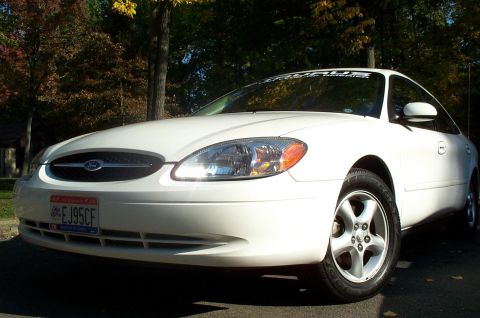 2001 Ford Taurus - A white sedan is parked outdoors, with trees in the background.