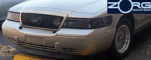 Gold 2000 Mercury Grand Marquis front grille and headlights, wire-spoke wheel, Zorg Industries logo in upper right