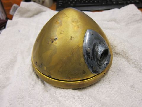 1987 Dodge 1500 - A brass headlight housing with a metal mounting bracket is shown, exhibiting signs of age and wear.