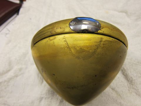 1987 Dodge 1500 - A brass headlight housing with engraved text indicating it is model 86 from Unity Manufacturing Company in Chicago, USA.