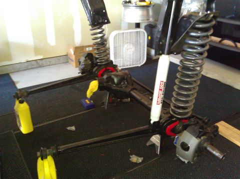 1995 Ford Bronco - Disassembled front axle assembly with suspension components, including coil springs and a shock absorber.