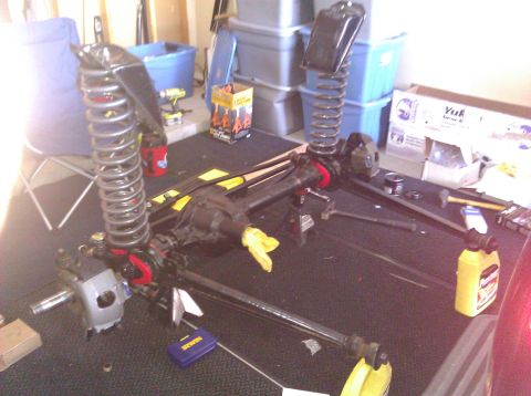1995 Ford Bronco - Vehicle suspension and axle components are disassembled and arranged on a surface, possibly for repair or modification.